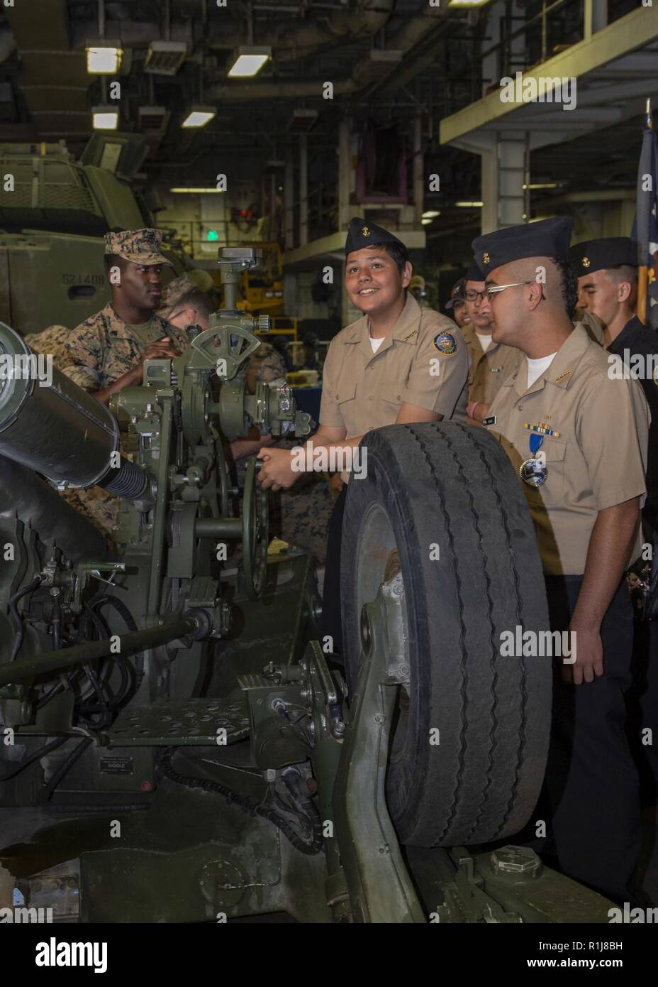 SAN FRANCISCO (Oct. 8, 2018) U.S. Navy Junior Reserve Officer Training Corps (JROTC) students from Everett Alvarez High School interact with an M-111 Alpha 2 Howitzer during a tour of the amphibious assault ship USS Bonhomme Richard (LHD 6) as part of San Francisco Fleet Week 2018. San Francisco Fleet Week is an opportunity for the American public to meet their Navy, Marine Corps and Coast Guard teams and experience America’s sea services. During fleet week, service members participate in various community service events, showcase capabilities and equipment to the community, and enjoy the hosp Stock Photo