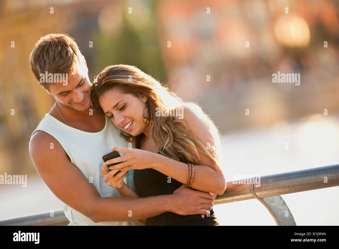 Young couple looking at something on a cell phone. Stock Photo