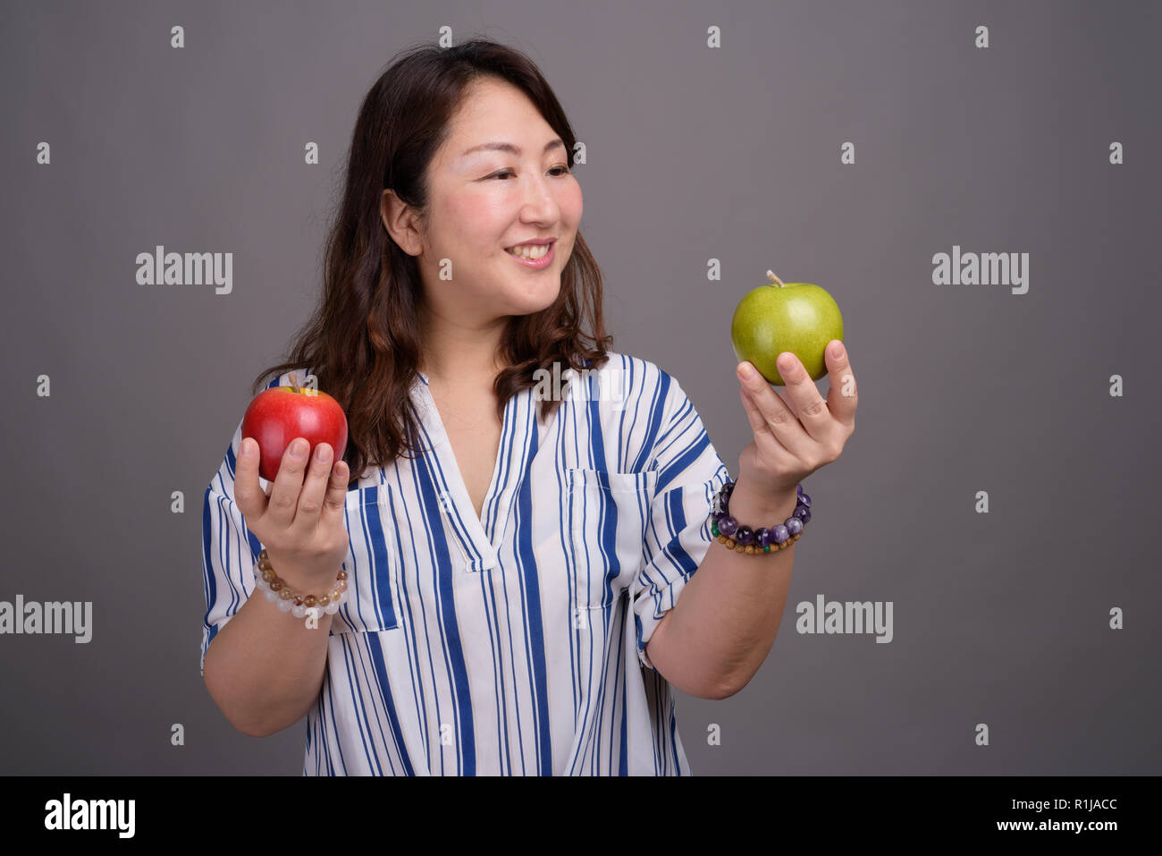 Full length portrait of Japanese businesswoman holding apple Stock Photo. 