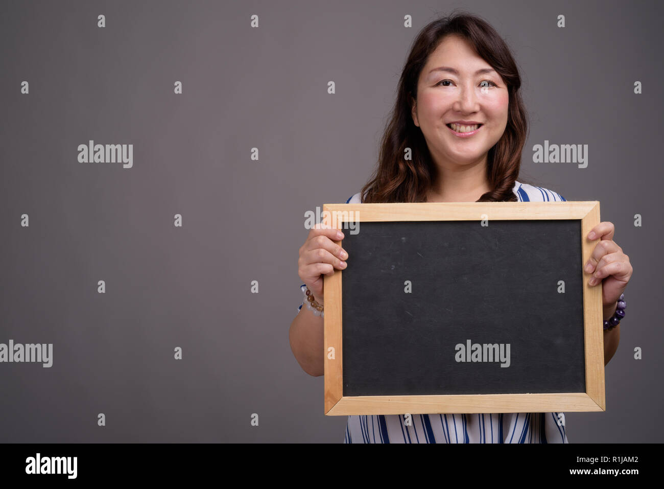 Asian businesswoman holding blackboard with copy space Stock Photo