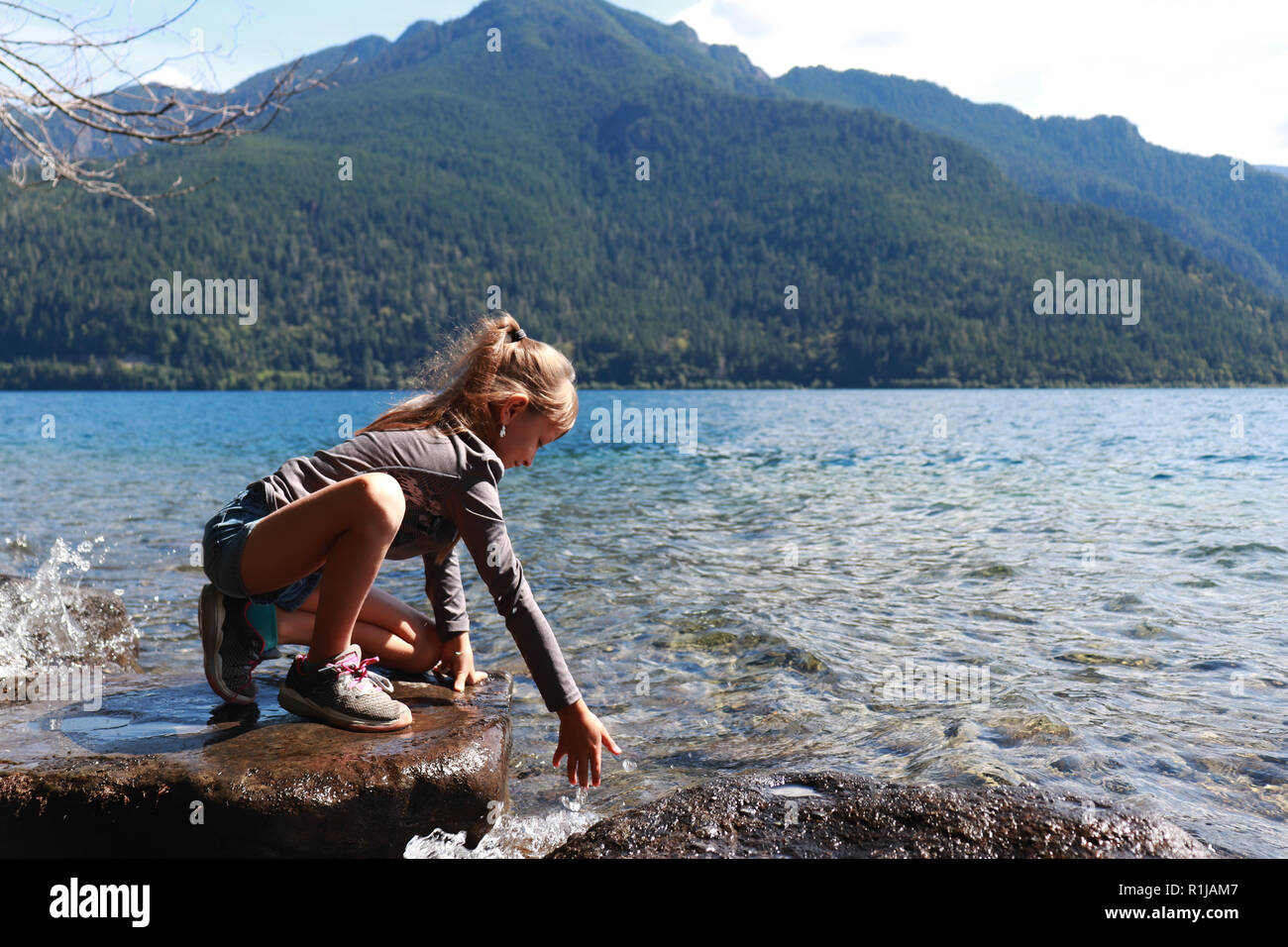 Little girl playing at Lake Crescent in Washington, Olympic National Forest. Stock Photo
