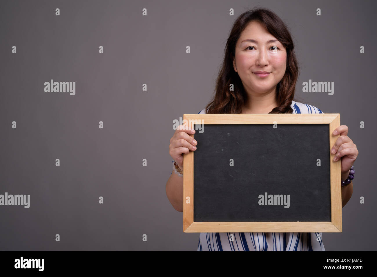 Asian businesswoman holding blackboard with copy space Stock Photo