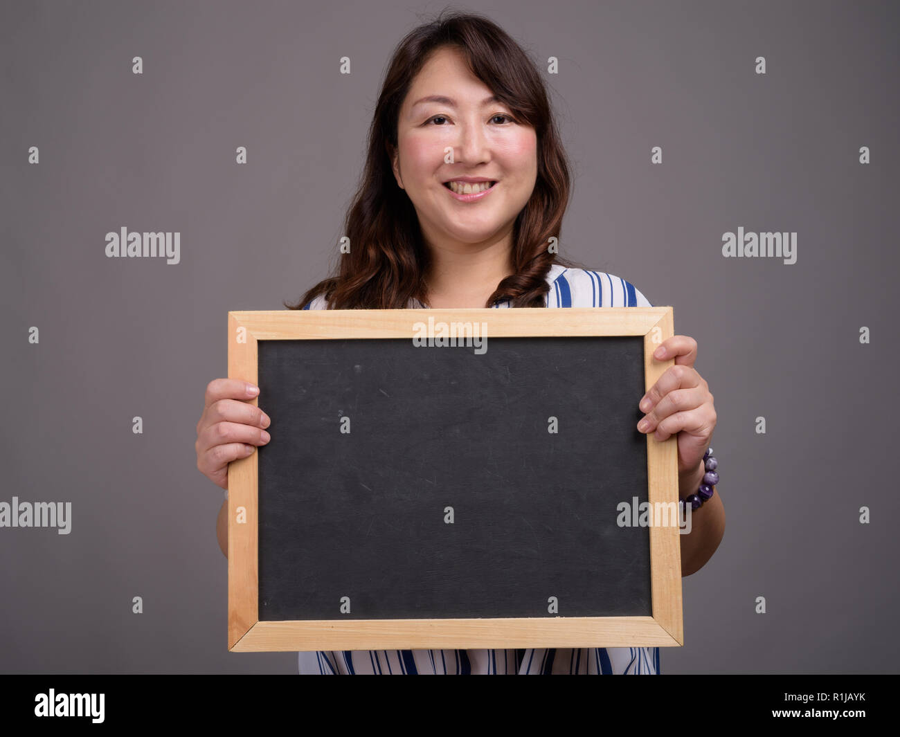 Asian businesswoman holding blackboard with copy space Stock Photo