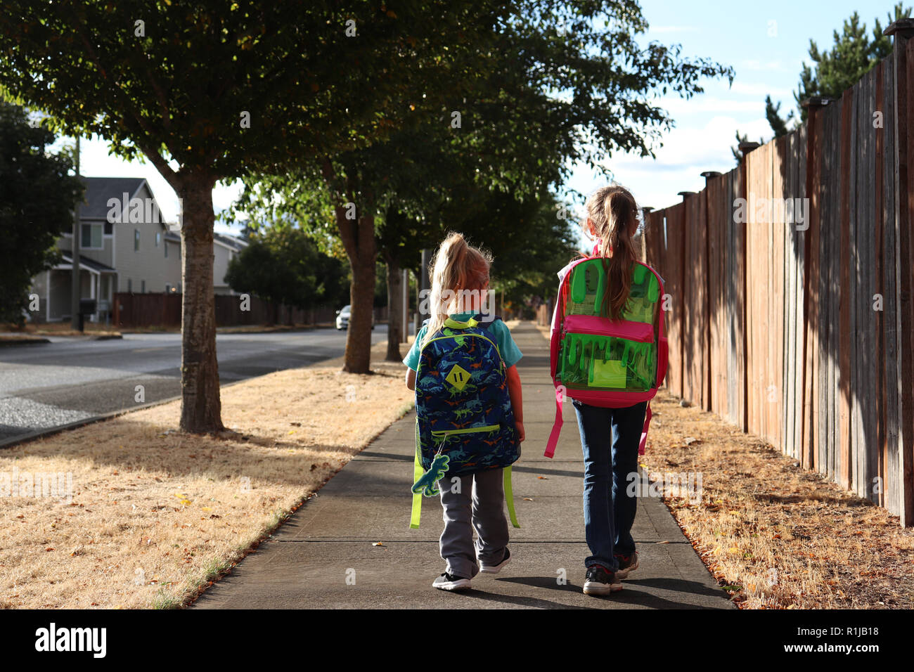 Two little girls on their way home from school Stock Photo - Alamy