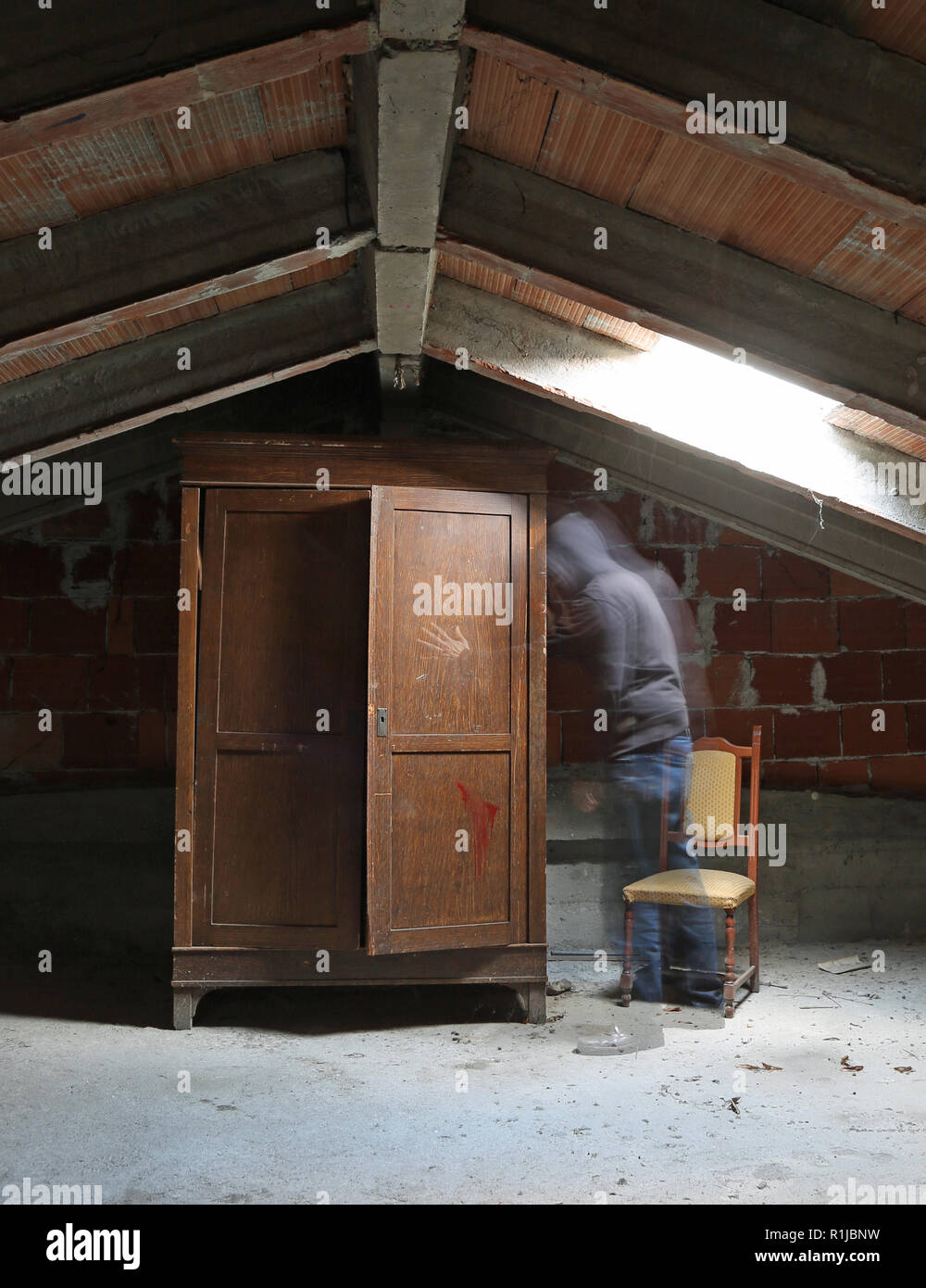 ghost and an old wardrobe in the attic of the abandoned house Stock