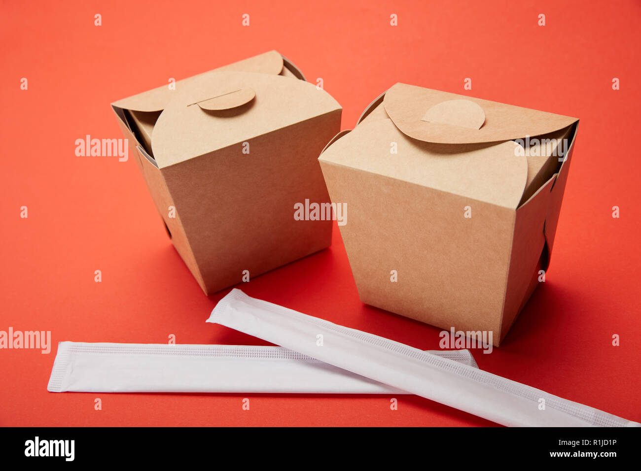 chopsticks and noodle boxes on red, minimalistic concept Stock Photo