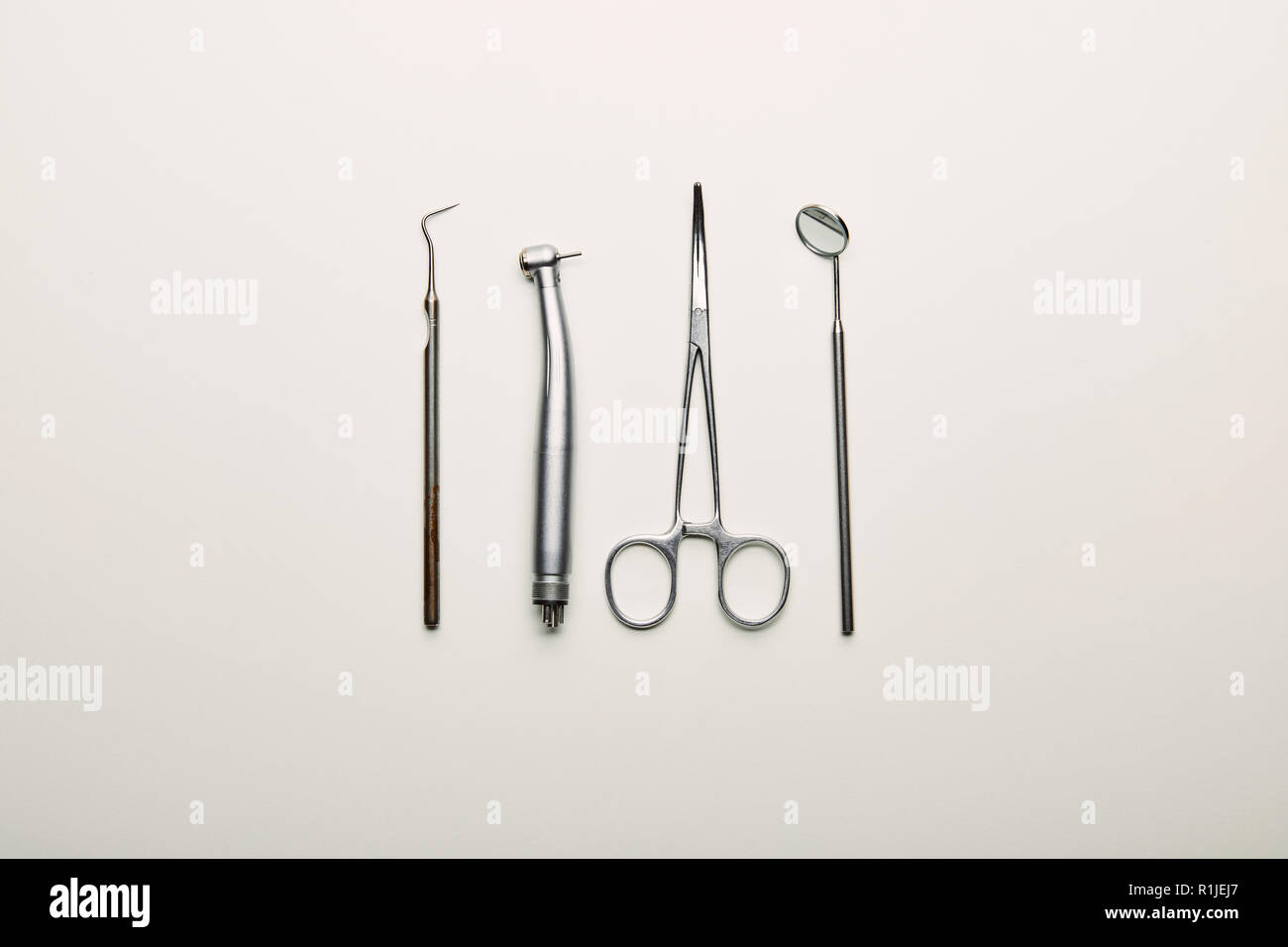 flat lay with stainless dental instruments arranged on white tabletop, dentistry concept Stock Photo