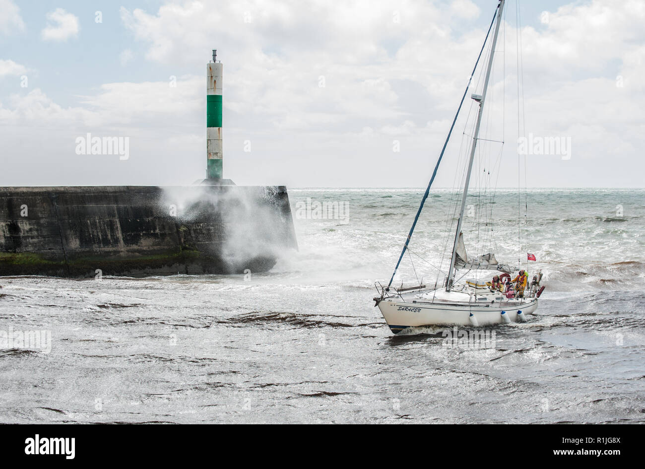 A yacht comes into Aberystwyth harbour to take shelter from the stormy seas. Stock Photo