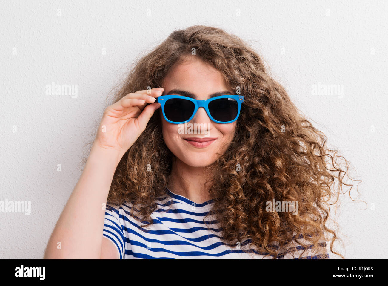 Young beautiful cheerful woman with sunglasses in studio. Stock Photo