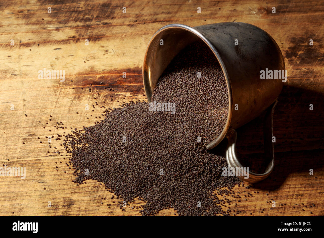 Poppy seed in the mug on a wood background Stock Photo
