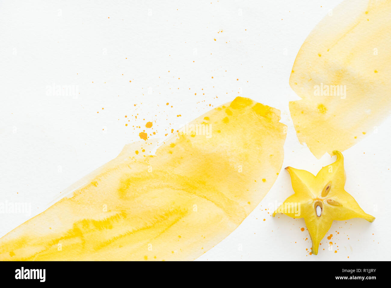 top view of sweet yummy star fruit on white surface with yellow watercolor Stock Photo