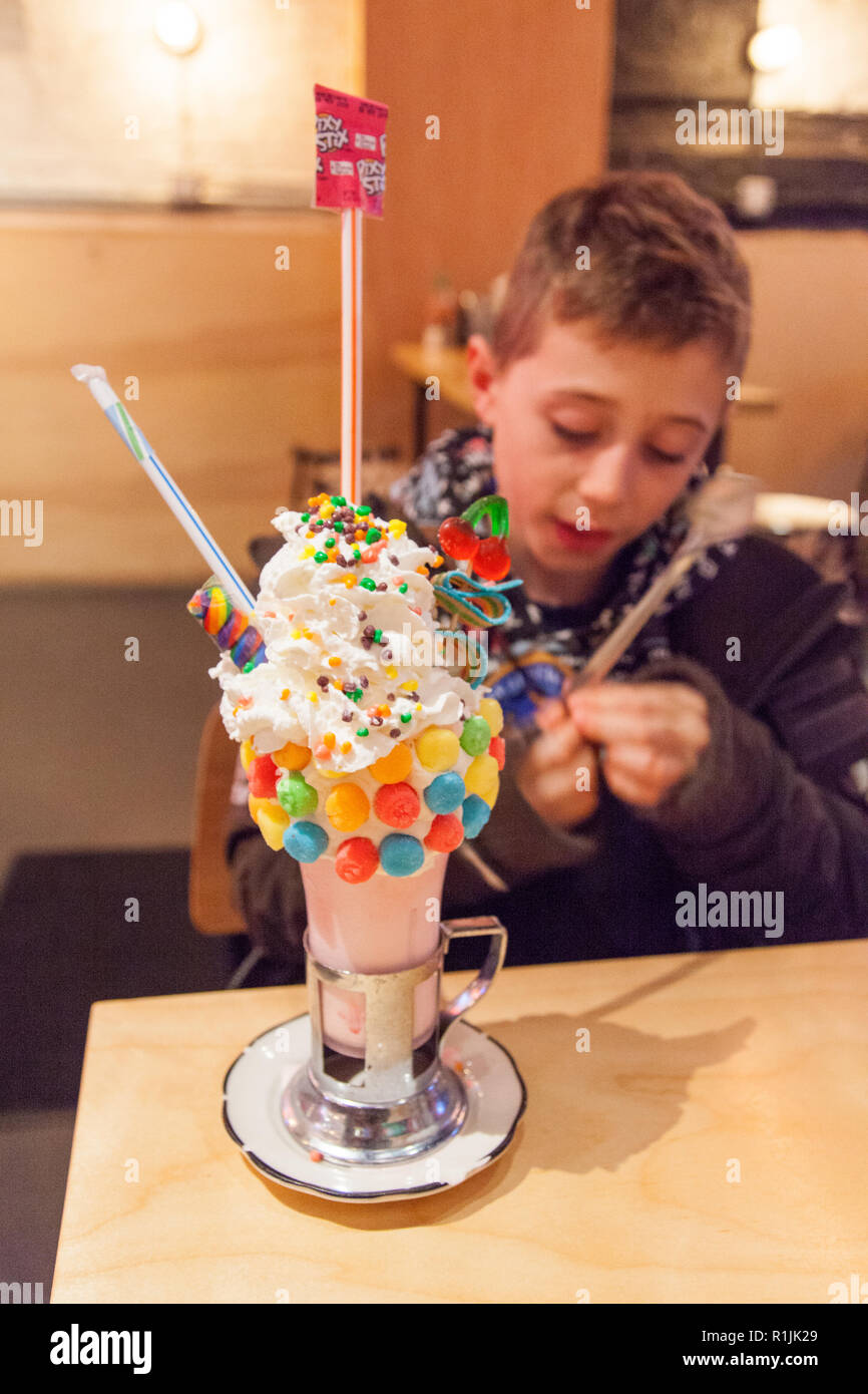 Nine year old boy with a Sour Power black cherry Crazy Shake milkshake, Black Tap, Ludlow St, Lower East Side, New York, United States of America. Stock Photo