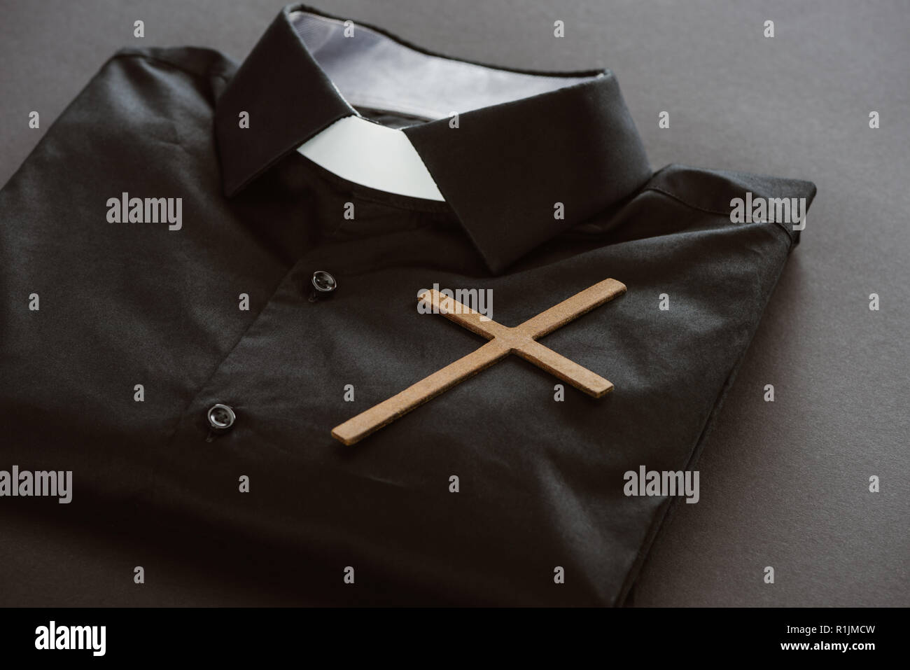 close-up shot of clerical shirt with cross on grey surface Stock Photo