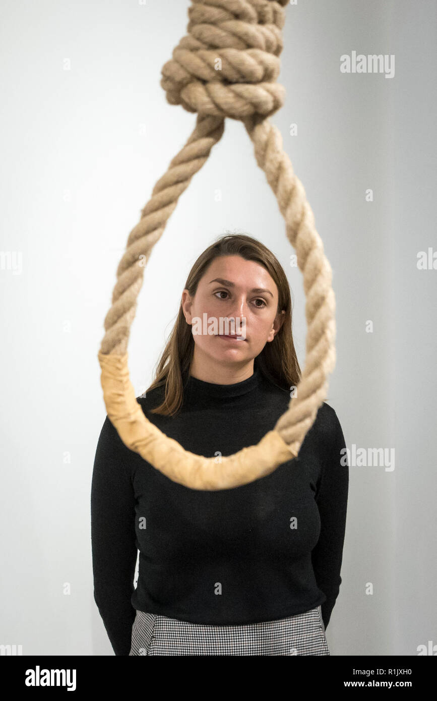 London, UK.  13 November 2018. A staff member views a hangman's noose.  Preview of 'Glad I Did It', a new work by Irish artist Christina Reihill at Bermondsey Project Space.  The interactive artwork looks at the life and death of Ruth Ellis, the last woman to be hanged in Britain, after she shot her lover, racing driver, David Blakely in 1955.  On display are the artist's interpretation of Ruth Ellis' prison cell, including furniture and props, the hanging room together with a video display of the artist in conversation. Credit: Stephen Chung/Alamy Live News Stock Photo