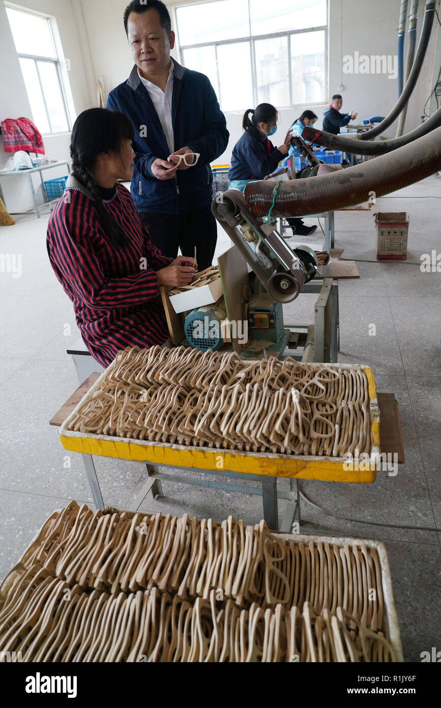 (181113) -- FENGXIN, Nov. 13, 2018 (Xinhua) -- A worker processes bamboo spectacle frames under Luo Xiaoping (2nd L)'s instruction at Luo's company in Fengxin Couny, east China's Jiangxi Province, Nov. 13, 2018. Luo Xiaoping, 42, went back to his hometown in Fengxin and started his bamboo spectacle frame business in 2014. With several technical breakthroughs, Luo and his team have applied for multiple patents, and have had their environment-friendly products made way to foreign markets. (Xinhua/Song Zhenping) (gxn) Stock Photo