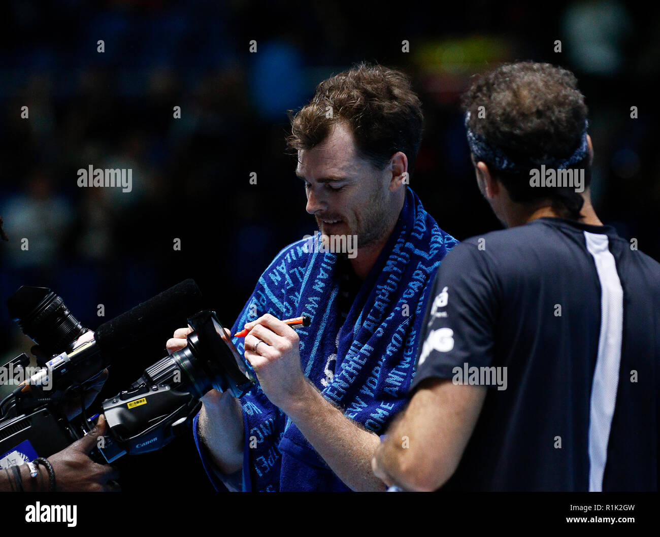 O2 Arena, London, England, UK, 13th November 2018. Nitto ATP Tennis Finals;  Jamie Murray (GBR) sign an autograph on a tv camera screen after defeating  Juan Sebastian Cabal (COL) and Robert Farah (