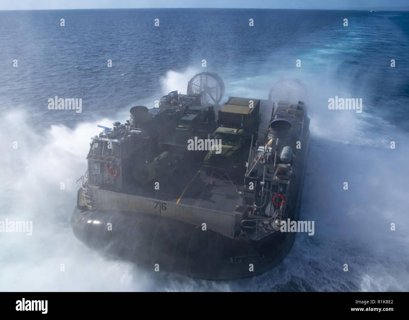 PACIFIC OCEAN (Oct. 10, 2018) Landing craft air cushion (LCAC) 76, assigned to Assault Craft Unit (ACU) 5, disembarks the well deck of the amphibious assault ship USS Bonhomme Richard (LHD 6). Bonhomme Richard is operating in the U.S. 3rd Fleet area of operations. Stock Photo