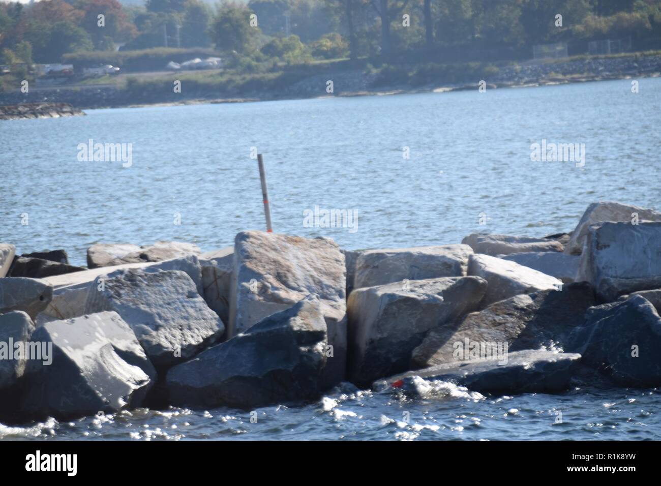 The west arrowhead breakwater at Oswego Harbor in Oswego, NY, October 10, 2018. The U.S. Army Corps of Engineers, Buffalo District is repairing 600 feet of the breakwater using armor stone in the 12-20 ton range. The repairs are critical to providing safe navigation and supports the local and national economies. Stock Photo