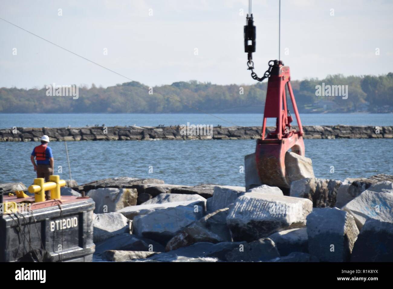 The U.S. Army Corps of Engineers, Buffalo District repairs the west arrowhead breakwater at Oswego Harbor in Oswego, NY, October 10, 2018. The project will repair 600 feet of the breakwater using armor stone in the 12-20 ton range. The repairs are critical to providing safe navigation and supports the local and national economies. Stock Photo