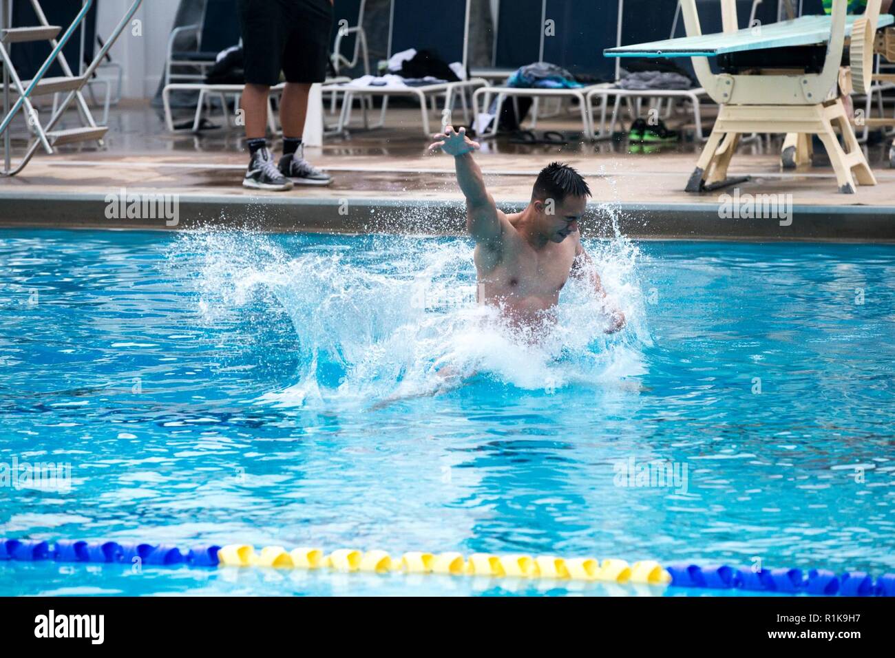 U.S. Marine Corps Cpl. Mathew Bangsoy, engineer equipment electrical systems technician, Marine Corps Tactical Systems Support Activity, Marine Corps Systems Command jumps into the water during the Commanding General’s (CG’s) Cup Dive Competition at the 13 Area Pool, Marine Corps Base Camp Pendleton, California, Oct. 11, 2018. The CG’s Cup is an intramural sports program that was developed to give service members from various units across MCB Camp Pendleton an opportunity to compete in organized sporting events in order to promote fitness, teamwork and esprit de corps. The CG’s cup also allows Stock Photo