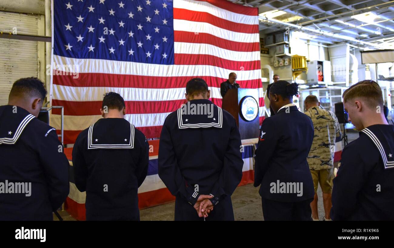 ALAMEDA, Calif. (Oct. 8, 2018) Sailors assigned to the amphibious assault ship USS Bonhomme Richard (LHD 6) bow their heads during an invocation aboard the USS Hornet Museum prior to a luncheon hosted by the Naval Order of the United States during San Francisco Fleet Week 2018. San Francisco Fleet Week is an opportunity for the American public to meet their Navy, Marine Corps and Coast Guard teams and experience America‚Äôs sea services. During San Francisco Fleet Week, service members participate in various community service events, showcase capabilities and equipment to the community, and en Stock Photo