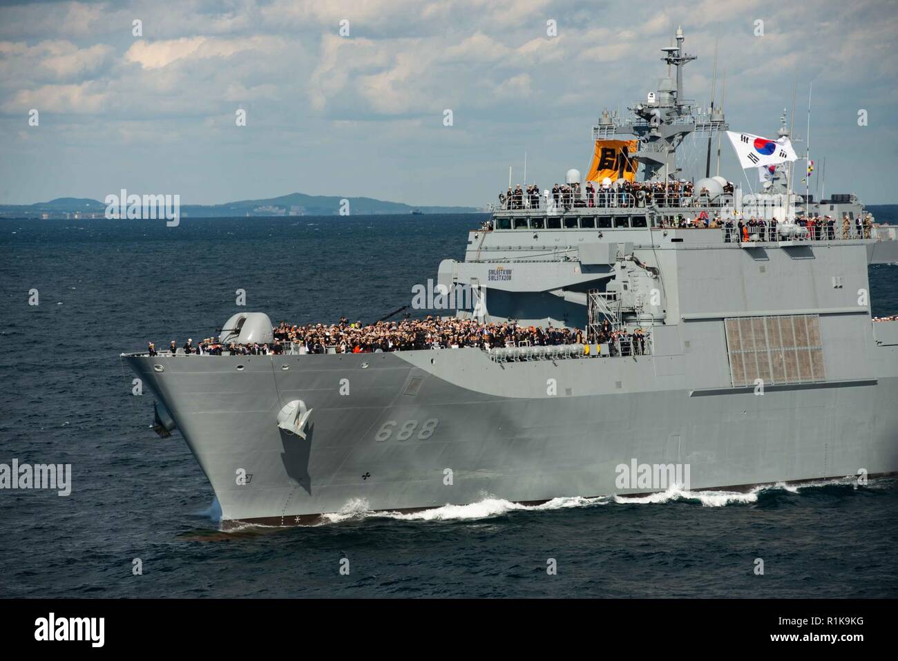 WATERS OFF THE KOREAN PENINSULA (Oct. 11, 2018) A crowd on the Republic of Korea (ROK) navy landing ship tank Ilchulbong (LST 688) observes multinational ships during a pass in review as part of the Republic of Korea International Fleet Review (IFR) 2018. IFR 2018 is hosted by the Republic of Korea Navy to help enhance mutual trust and confidence with navies from around the world. The forward-deployed aircraft carrier USS Ronald Reagan (CVN 76) is forward-deployed to the U.S. 7th Fleet area of operations in support of security and stability in the Indo-Pacific region. Stock Photo