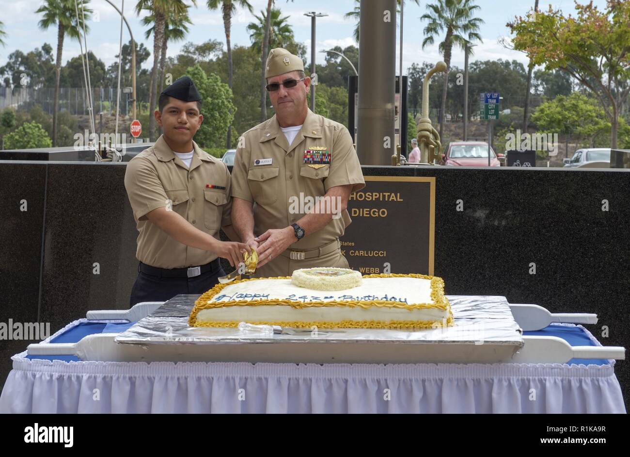 SAN DIEIGO (Oct. 12,2018) — Cmdr Michael Murry, the oldest Sailor present, and Hospitalman Apprentice Lopez cut the cake during Naval Medical Center San Diego (NMCSD) celebration in the courtyard for the Navy’s 243rd Birthday. NMCSD is the largest naval hospital on the west coast, employing more than 6,000 Sailors, civilians and contractors. Stock Photo