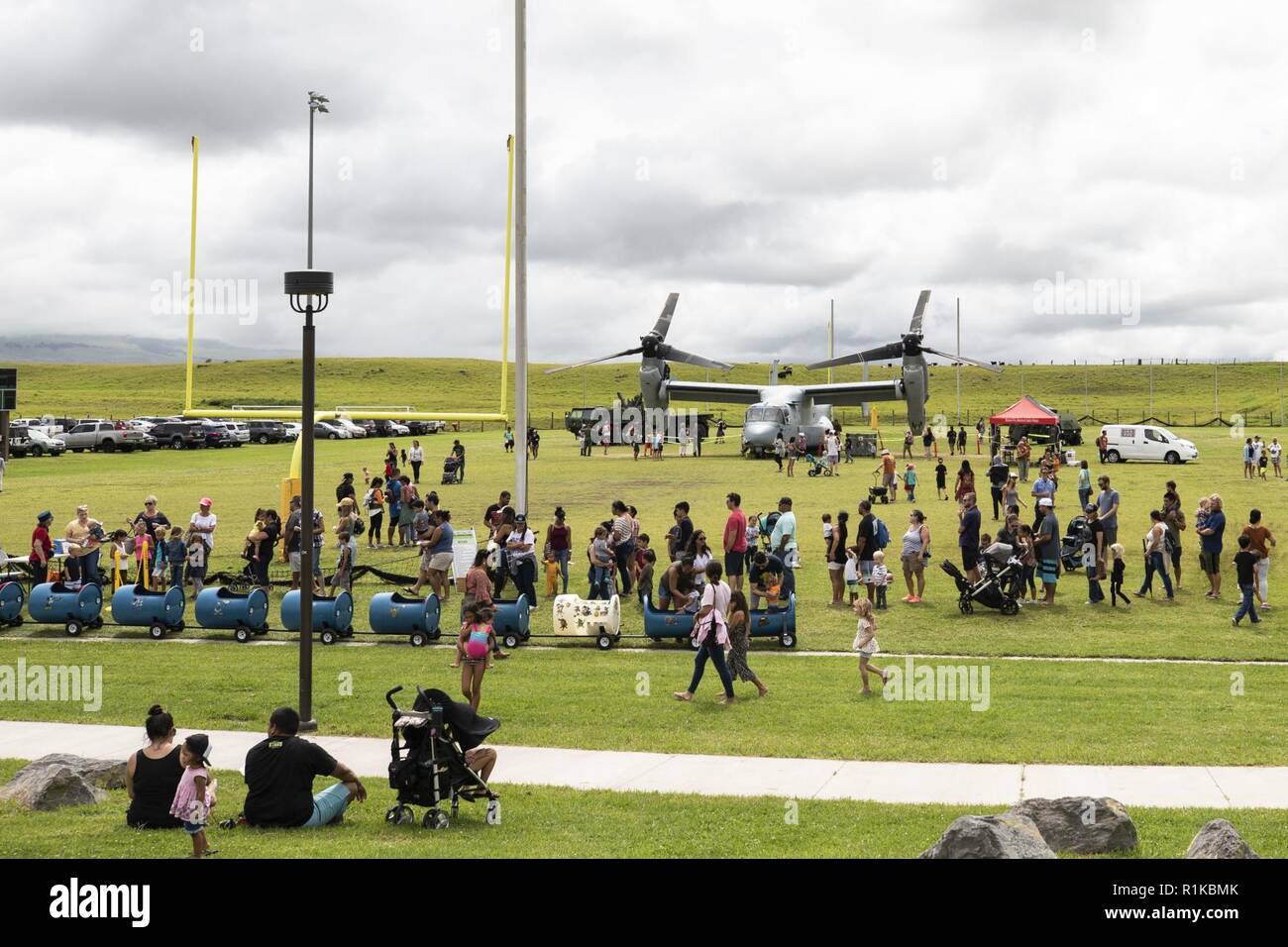 U.S. Marines with Marine Medium Tiltrotor Squadron (VMM) 363, attend the Waimea Fall Festival at the Waimea District Park with a static display of one of their MV-22B Osprey aircraft, Oct. 13, 2018. VMM-363 flew one of their aircraft from Marine Corps Base Hawaii on Oahu to the Waimea Fall Festival, providing a static display and subject matter experts for a first-hand experience to the festival’s attendants. The squadron arrived to Hawaii earlier this year increasing the combat capability and crisis response within the Indo-Pacific region. Stock Photo