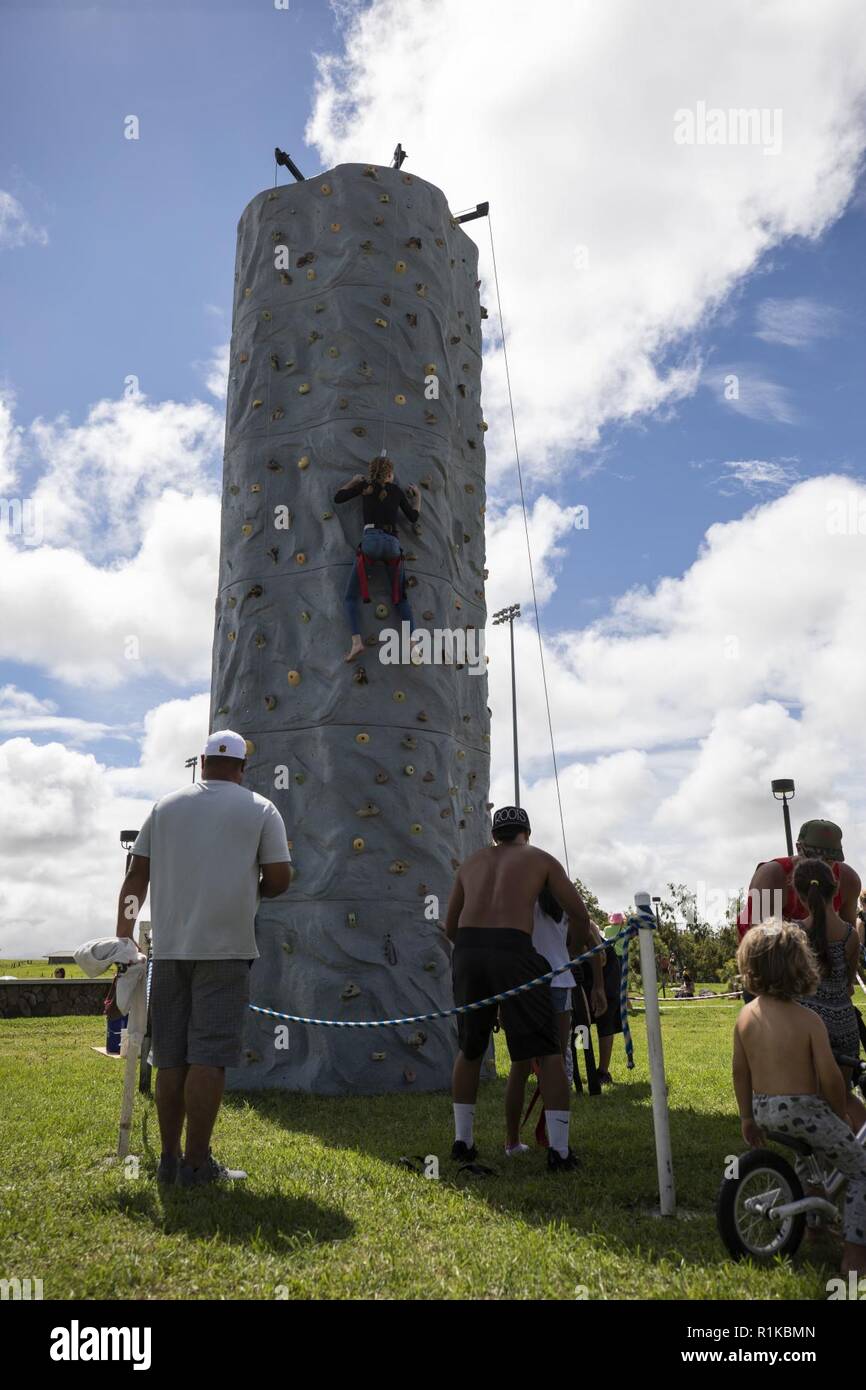 A rock climbing wall is set up during the Waimea Fall Festival at the Waimea District Park, Oct. 13, 2018. U.S. Marines with Marine Medium Tiltrotor Squadron (VMM) 363, nicknamed the Lucky Red Lions, flew one of their aircraft from Marine Corps Base Hawaii on Oahu to the Waimea Fall Festival, providing a static display and subject matter experts for a first-hand experience to the festival’s attendants. The squadron arrived to Hawaii earlier this year increasing the combat capability and crisis response within the Indo-Pacific region. Stock Photo