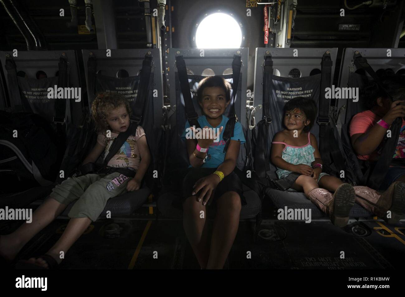 Children sit down and pose for a photo inside a MV-22B Osprey aircraft during the Waimea Fall Festival at the Waimea District Park, Oct. 13, 2018. U.S. Marines with Marine Medium Tiltrotor Squadron (VMM) 363, nicknamed the Lucky Red Lions, flew one of their aircraft from Marine Corps Base Hawaii on Oahu to the Waimea Fall Festival, providing a static display and subject matter experts for a first-hand experience to the festival’s attendants. The squadron arrived to Hawaii earlier this year increasing the combat capability and crisis response within the Indo-Pacific region. Stock Photo