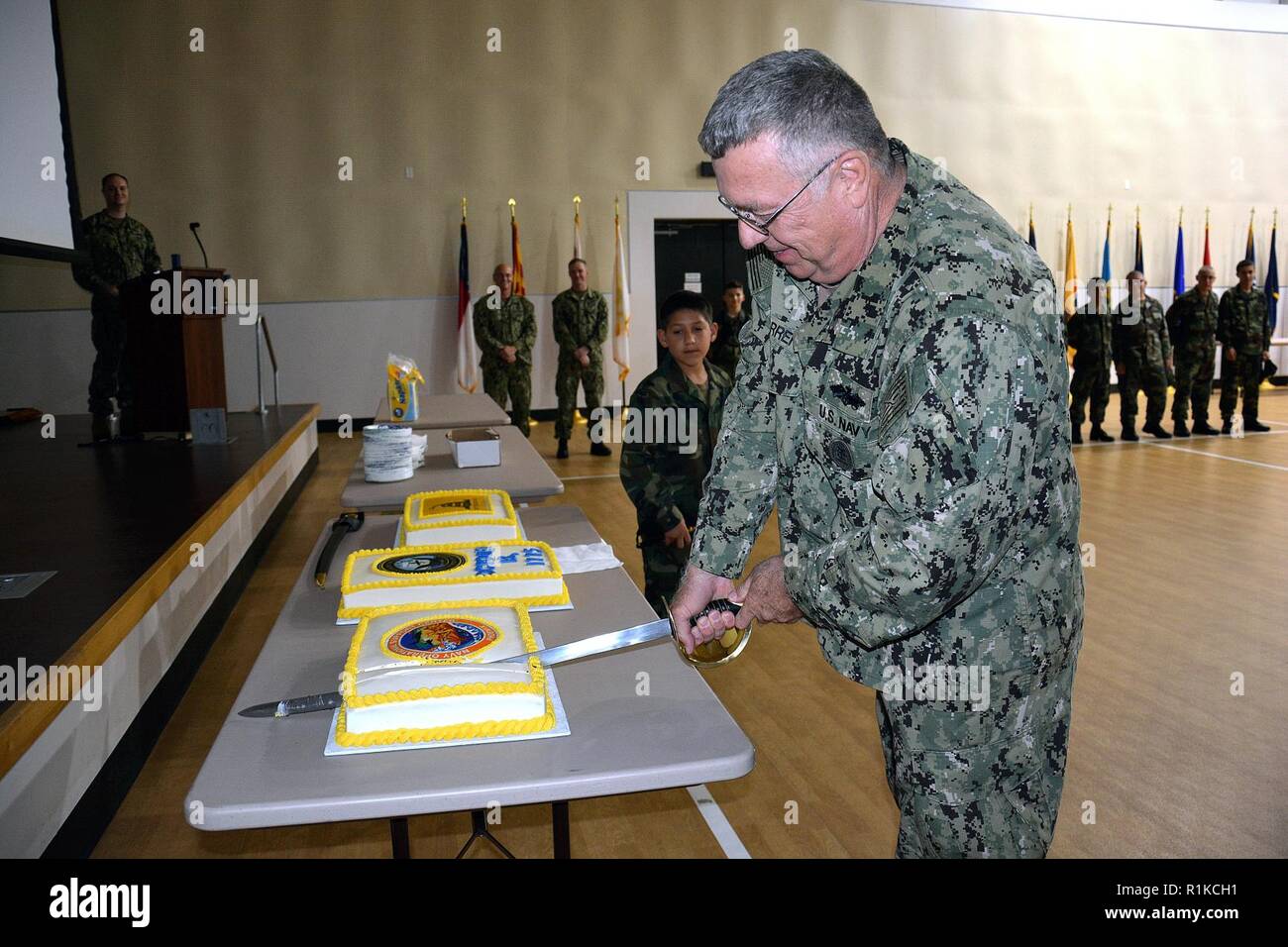 Master Chief Navy Equipmentman William W. Warren cuts a cake in in celebration of the Navy’s 243rd birthday. In keeping with military tradition of past and present, the youngest and oldest members participate in the ceremonial cutting of the cake. U.S. Naval Sea Cadet Corps Recruit Moreland was the youngest member in attendance while Master Chief Navy Equipmentman William W. Warren was the oldest. The U.S. Navy traces its origins to the Continental Navy, established during the War of Independence by the Continental Congress on October 13, 1775. Stock Photo