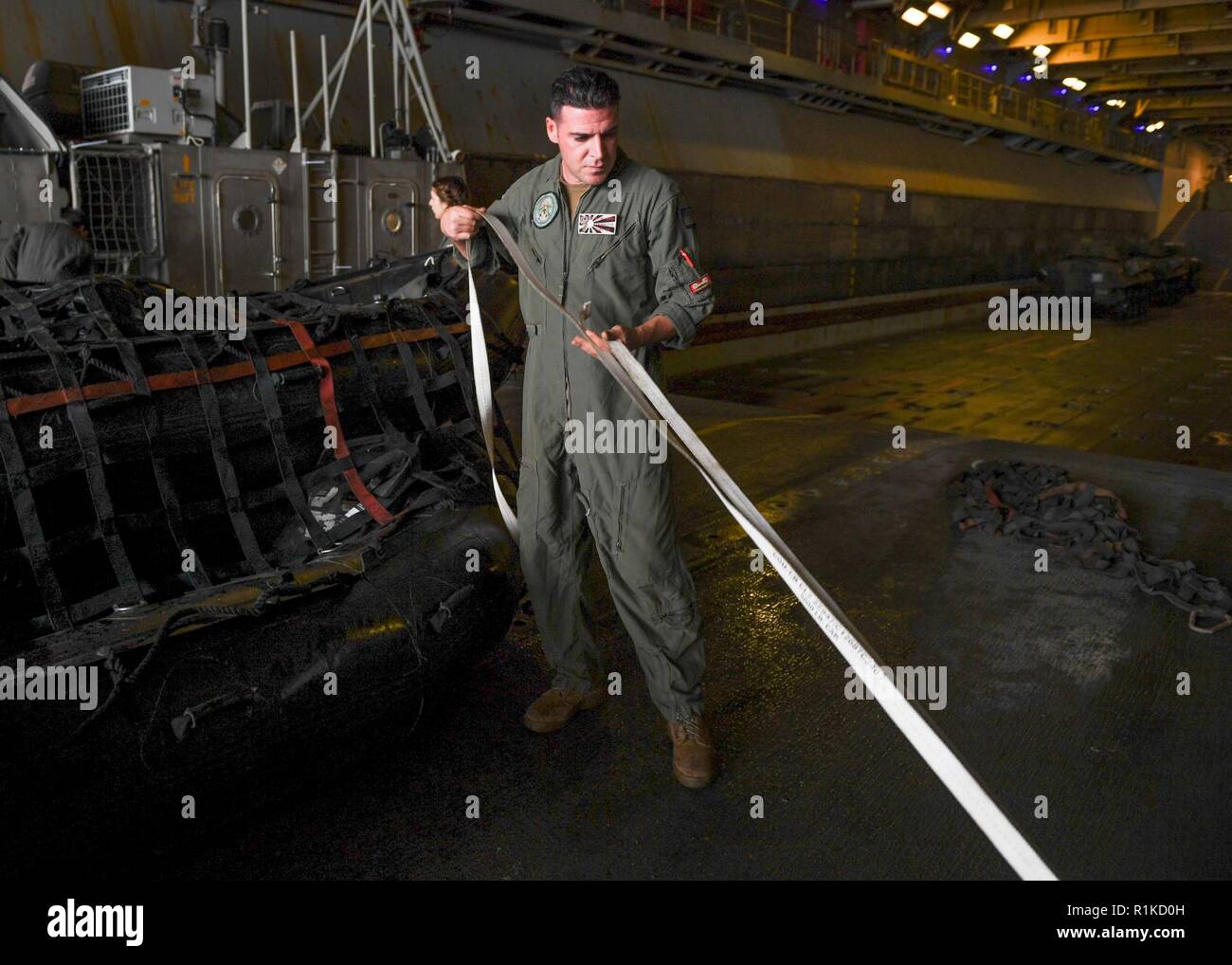 EAST CHINA SEA (Oct. 14, 2018) Boatswain’s Mate 1st Class Benny Genovese, assigned to Naval Beach Unit 7, prepares to strap down a combat raiding rubber craft aboard a landing craft, air cushion, in the well deck of the amphibious assault ship USS Wasp (LHD 1) during integrated unit level training. Wasp, flagship of Wasp Amphibious Ready Group, with embarked 31st Marine Expeditionary Unit, is operating in the Indo-Pacific region to enhance interoperability with partners and serve as a ready-response force for any type of contingency. Stock Photo