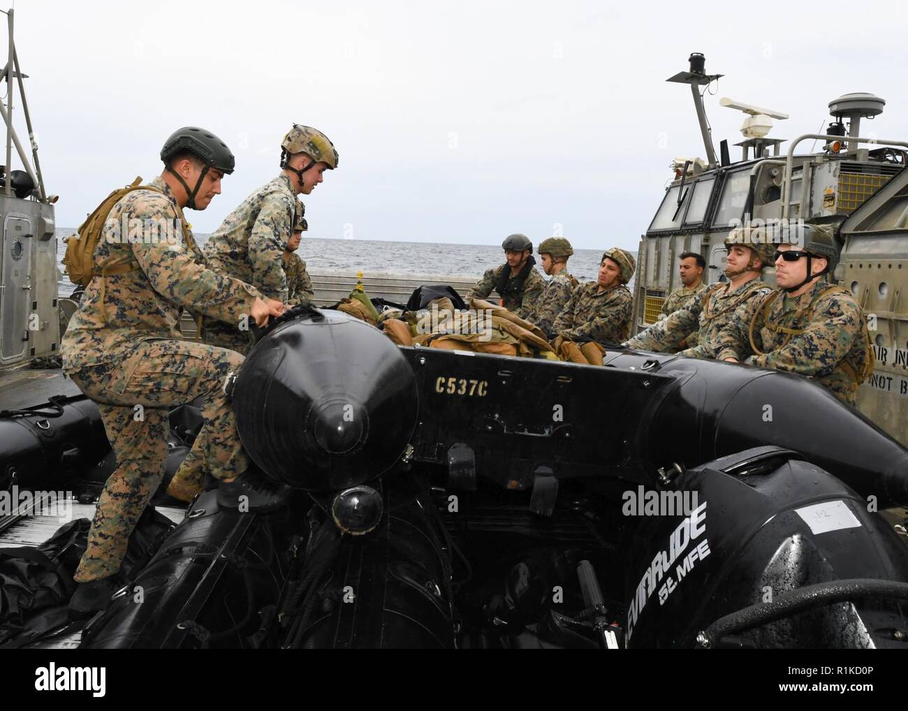 EAST CHINA SEA (Oct. 14, 2018) Marines, assigned to the 31st Marine Expeditionary Unit (MEU), prepare to launch a combat raiding rubber craft aboard a landing craft, air cushion, assigned to Naval Beach Unit 7,  during integrated unit level training. The amphibious assault ship USS Wasp (LHD 1), flagship of Wasp Amphibious Ready Group, with embarked 31st MEU, is operating in the Indo-Pacific region to enhance interoperability with partners and serve as a ready-response force for any type of contingency. Stock Photo