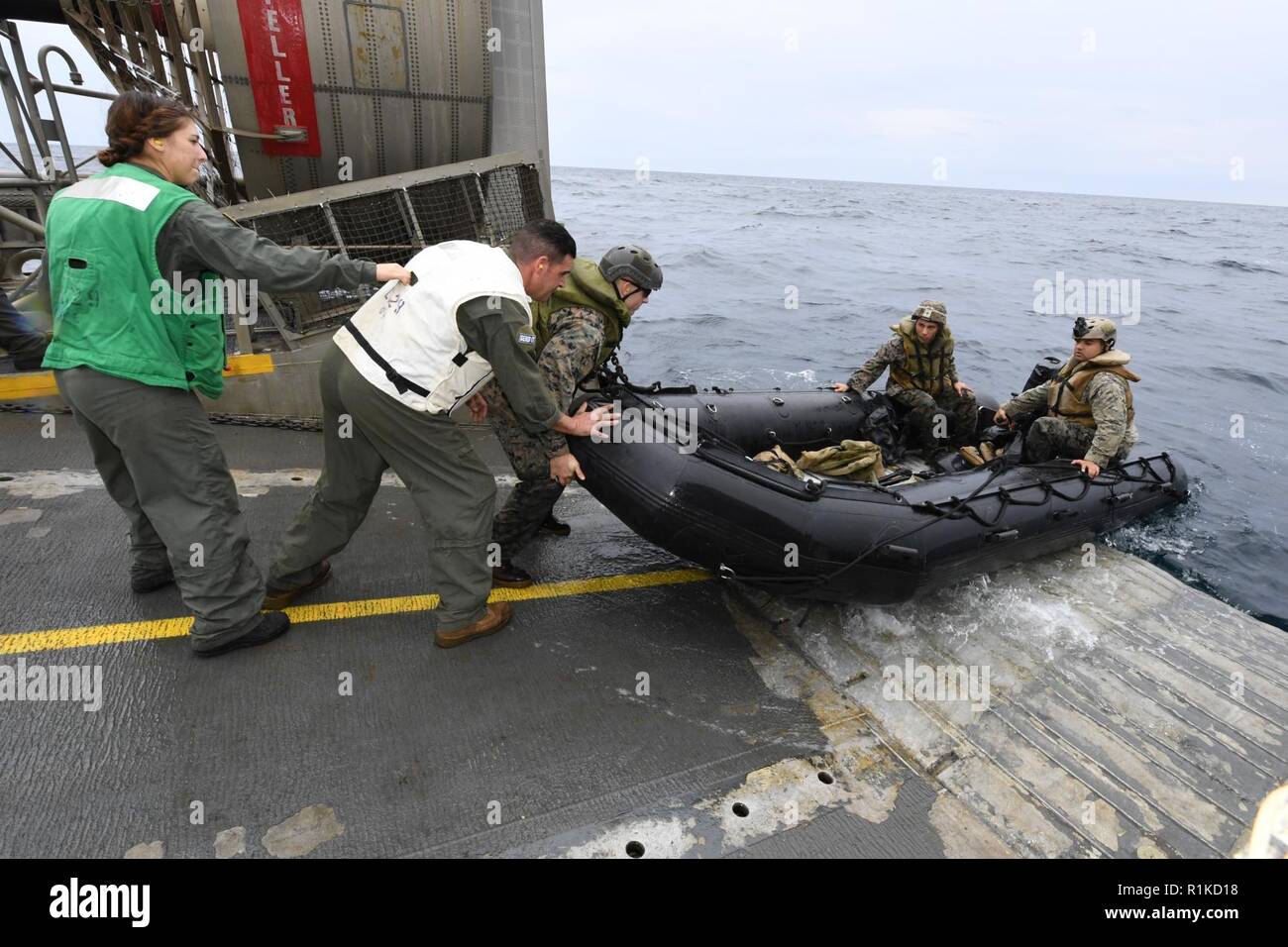 EAST CHINA SEA (Oct. 14, 2018) Sailors, assigned to Naval Beach Unit 7,  assist Marines assigned to the 31st Marine Expeditionary Unit (MEU), launch a combat rubber raiding craft into the water aboard a landing craft, air cushion, during integrated unit level training. The amphibious assault ship USS Wasp (LHD 1), flagship of Wasp Amphibious Ready Group, with embarked 31st MEU, is operating in the Indo-Pacific region to enhance interoperability with partners and serve as a ready-response force for any type of contingency. Stock Photo
