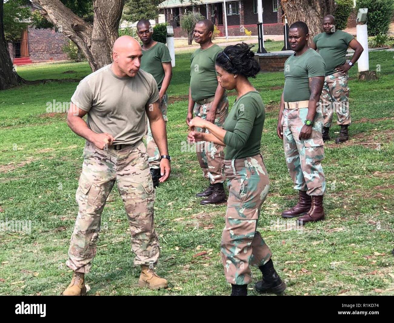 New York Army National Guard Master Sgt. Luis Barsallo, a certified hand-to-hand tactics instructor, demonstrates a move to members of the South African National Defense Forces during an  exchange visit on October 10, 2018. Soldiers from the New York Army National Guard took  part in an exchange program at the South African National Defense Forces Military Police School during an exchange visit there on Oct. 10-11, 2018. Twelve New York Army National Guard experts in civil support operations, military police, law enforcement, and self-defense took part in the exchange visit. ( U.S. Army Nation Stock Photo