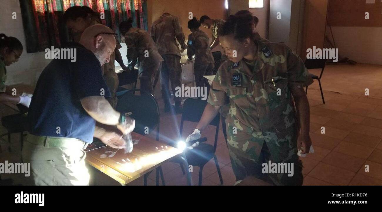 Naval Criminal Investigative Service Special Agent David Reid teaches evidence collection techniques to  South African Military Police Soldiers during an exchange visit on October 10, 2018. Soldiers from the New York Army National Guard also took  part in the  exchange program at the South African National Defense Forces Military Police School during an exchange visit there on Oct. 10-11, 2018. Twelve New York Army National Guard experts in civil support operations, military police, law enforcement, and self-defense took part in the exchange visit. ( U.S. Army National Guard phot by Sgt. Krist Stock Photo