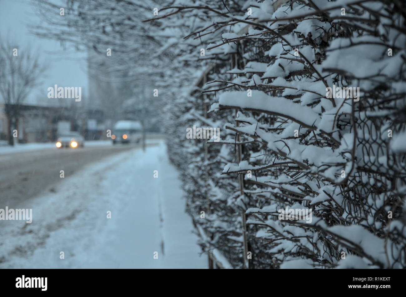 Snow-covered street in the city. Car and street under the snow after heavy snowfall. Stock Photo