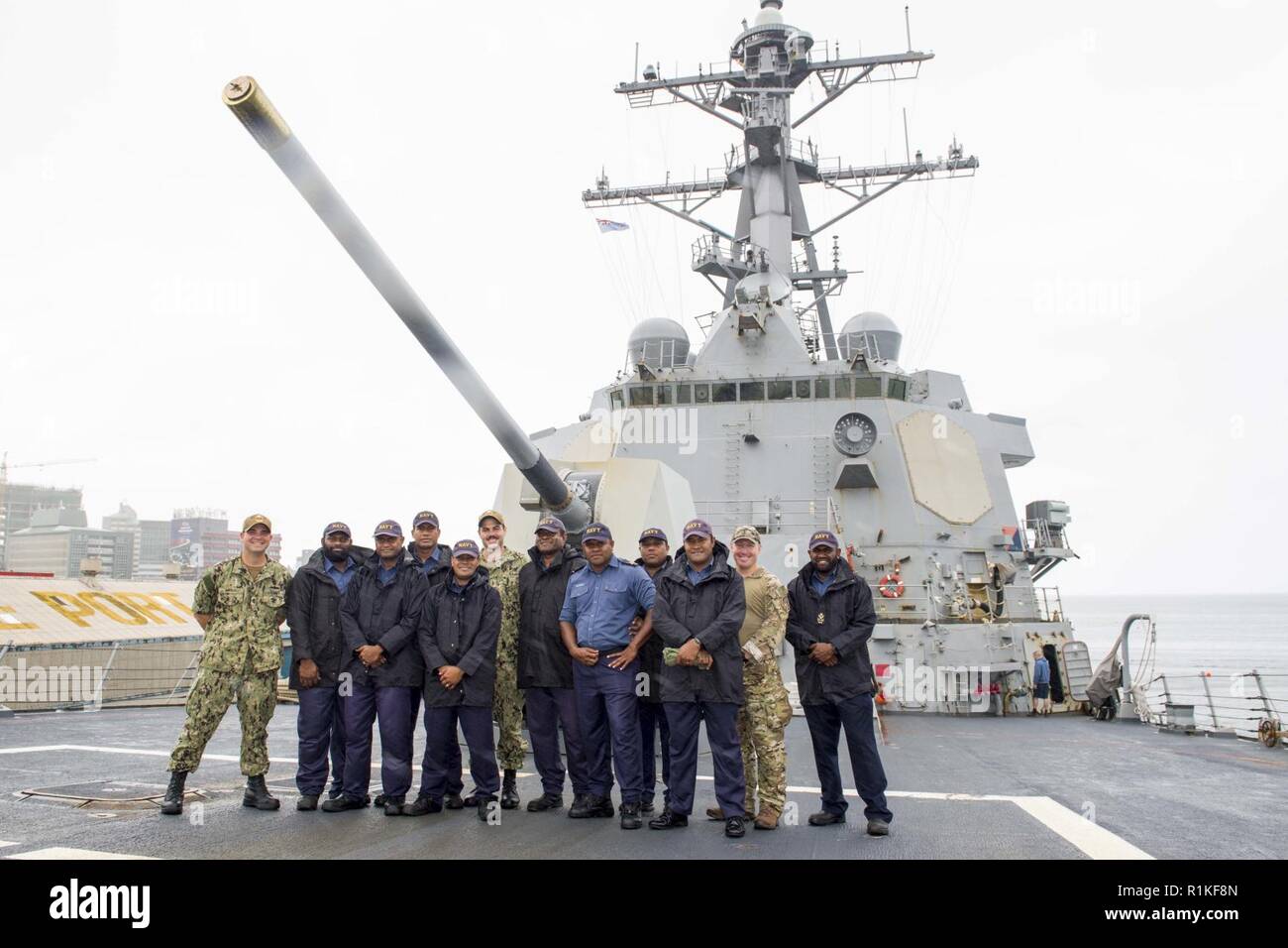 PORT OF SUVA, Fiji (Oct. 16, 2018) Sailors and Coast Guardsman, assigned to the Arleigh Burke-class guided-missile destroyer USS Shoup (DDG 86), pose for a photo with sailors of the Republic of Fiji Military Forces after a symposium during a recent port visit in Suva, Fiji Oct. 16, 2018. Shoup is currently participating in the Oceania Maritime Security Initiative (OMSI) program, a Secretary of Defense program leveraging Department of Defense assets transiting the region to increase the Coast Guard’s maritime domain awareness, ultimately supporting its maritime law enforcement operations in Oce Stock Photo