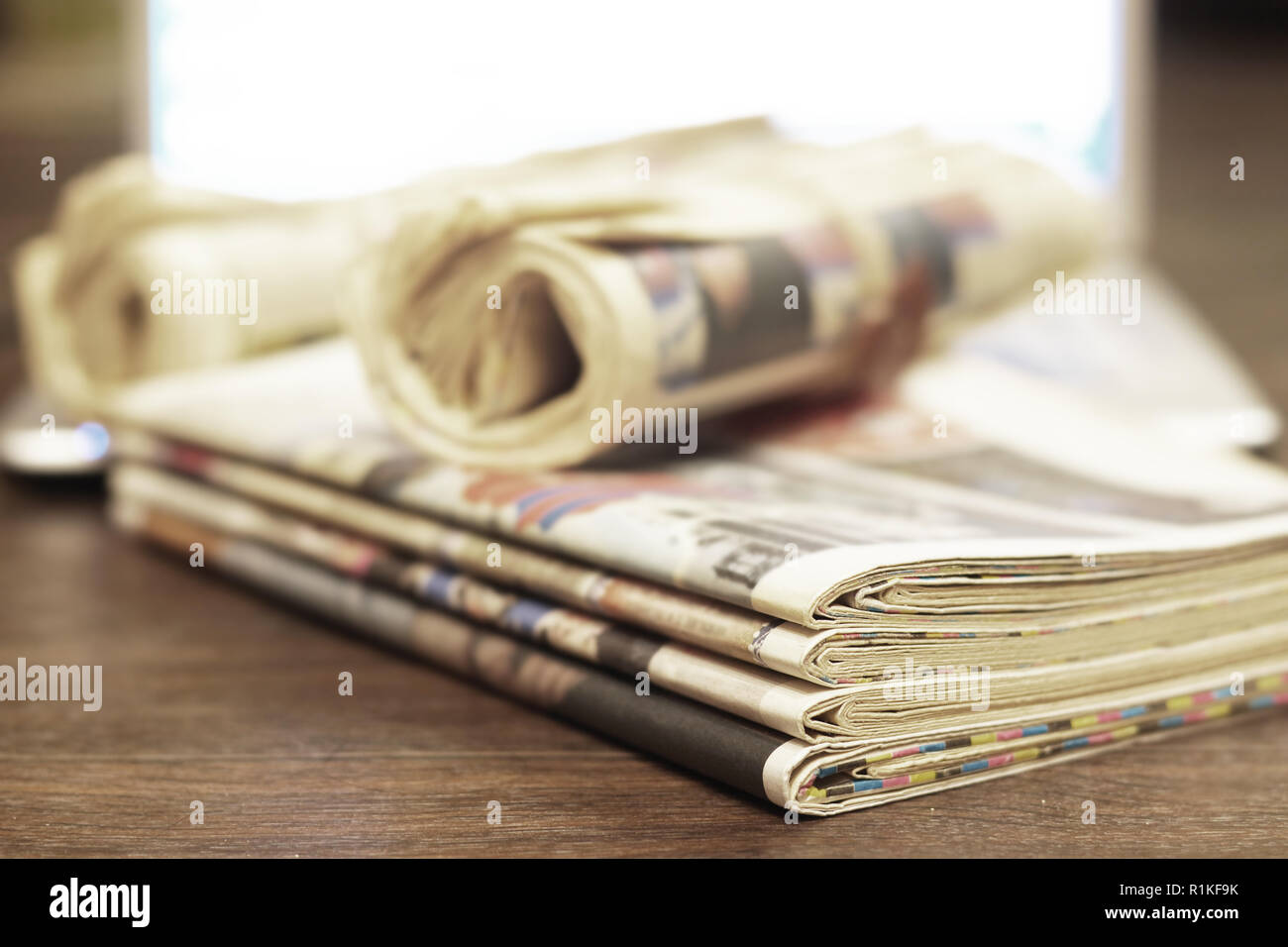 Pile of fresh morning newspapers on table at office. Latest financial and business news in daily paper. Pages with headlines, articles, photos, tex Stock Photo
