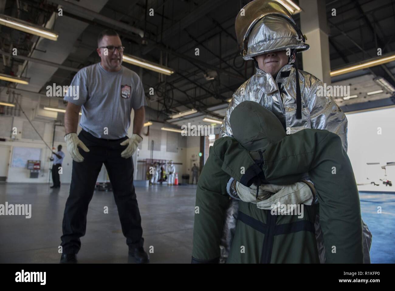 A Fire Prevention Week challenge competitor carries a dummy at Joint Base LangleyEustis