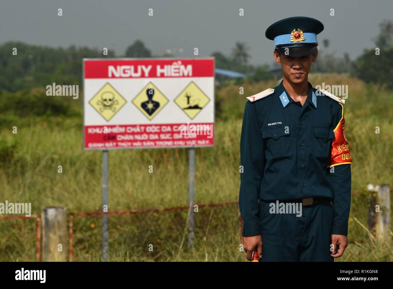 A Vietnamese Air Defense Air Force member stands watch in front of a dioxin-contaminated site at the Bien Hoa Air Base outside Ho Chi Minh City, Vietnam, during a visit by U.S. Secretary of Defense James N. Mattis, Oct. 17, 2018. Stock Photo