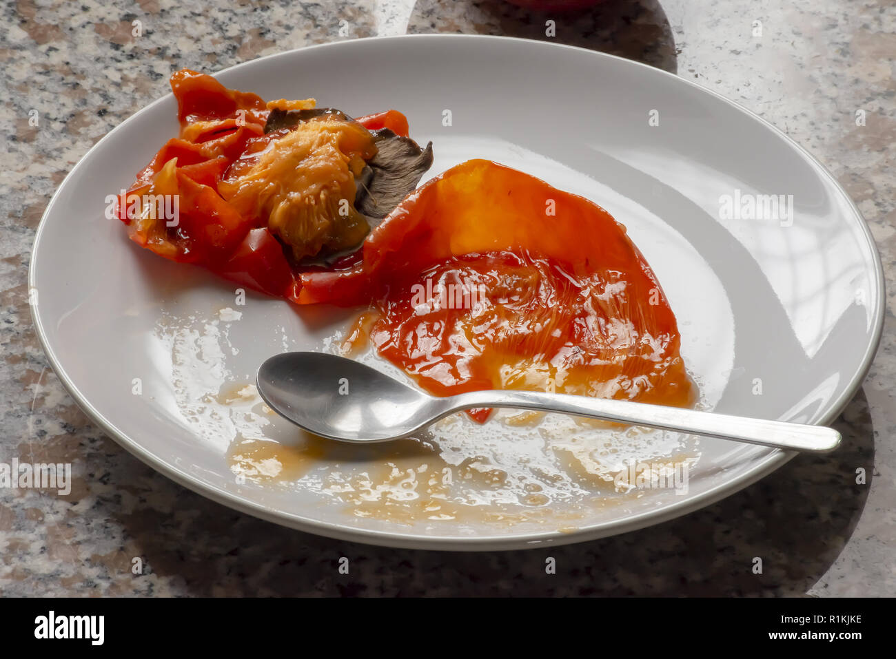 kaki fruit in the dish ate everything from above Stock Photo