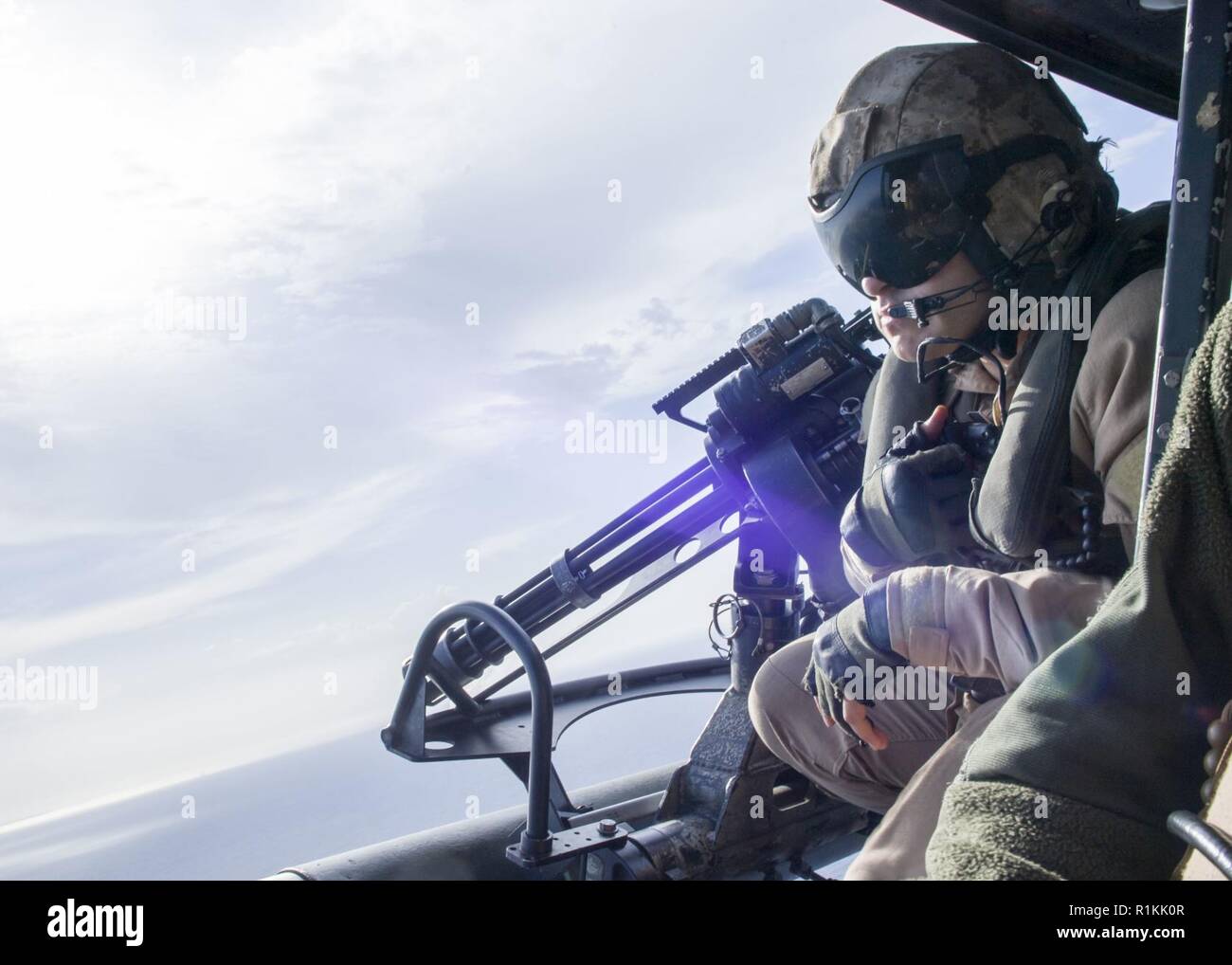 MEDITERRANEAN SEA (Oct. 15, 2018) U.S. Marines Cpl. Daniel Rios, assigned to Marine Medium Tiltrotor Squadron (VMM) 166 (Reinforced), mans a GAU-17/A mini gun on a UH-1Y Venom helicopter during a live-fire exercise while embarked on the San Antonio-class amphibious transport dock ship USS Anchorage (LPD 23), in the Mediterranean Sea, Oct 15, 2018. Anchorage and embarked 13th Marine Expeditionary Unit are deployed to the U.S. 6th Fleet area of operations as a crisis response force in support of regional partners as well as to promote U.S. national security interests in Europe and Africa. Stock Photo