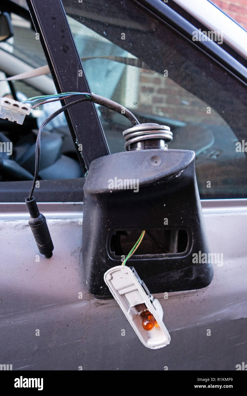 Broken drivers wing mirror hanging off a written off crash damaged citroen c4 car on a recovery