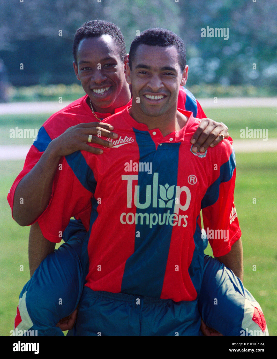 Mark Bright (Crystal Palace) wearing the team's new strip showing their new sponsor, Tulip Computers, carries teammate Ian Wright during a photocall at the Football Association's Lancaster Gate headquarters. Stock Photo