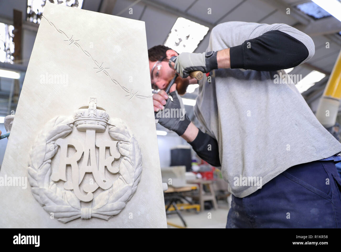 Stone masons from Salisbury cathedral work on a war memorial in their workshop which was designed by prisoners from Erlestoke prison in Wiltshire, and will be placed outside the prison's visitor's centre. Stock Photo