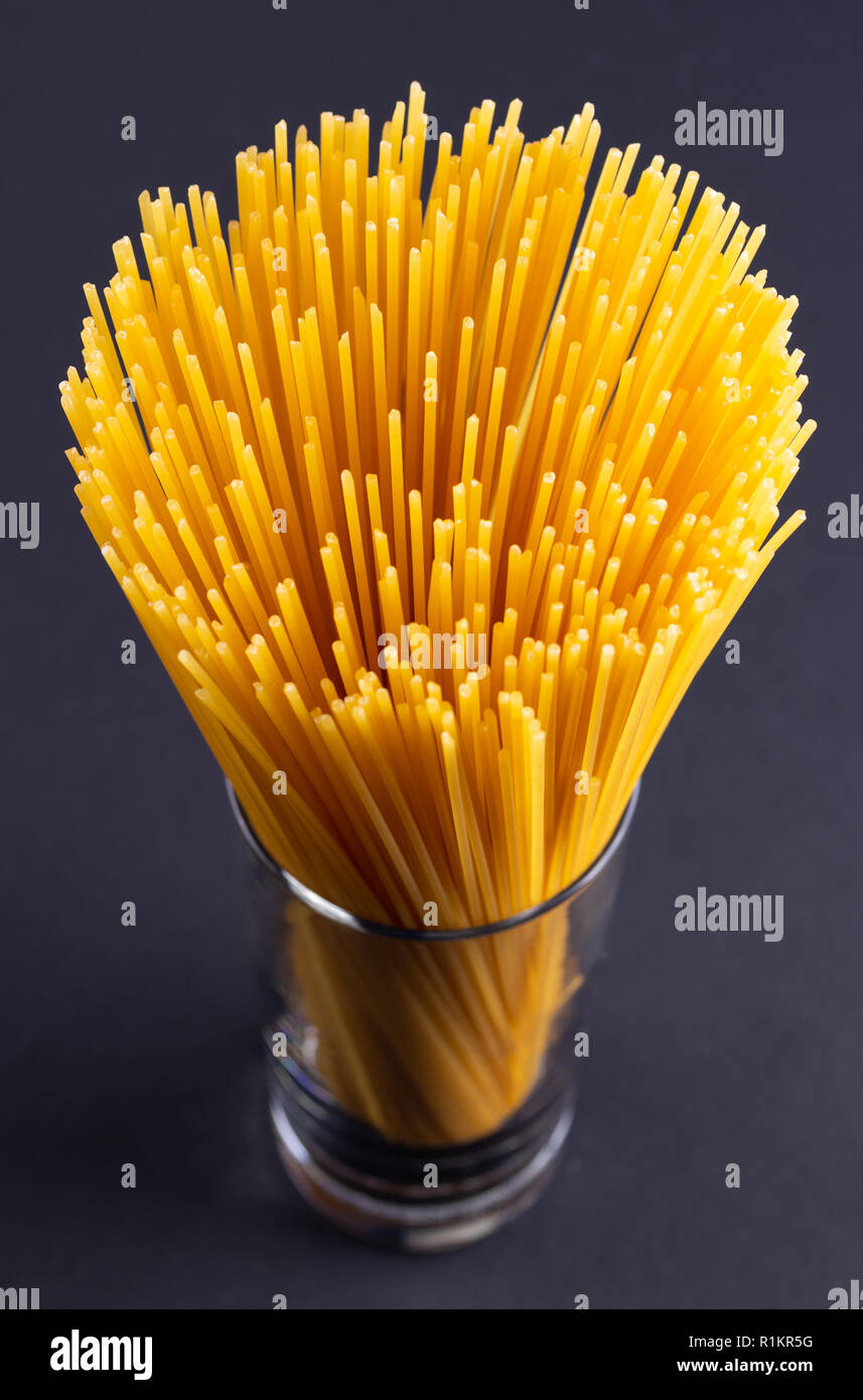 A bouquet of spaghetti in glass on a dark background Stock Photo