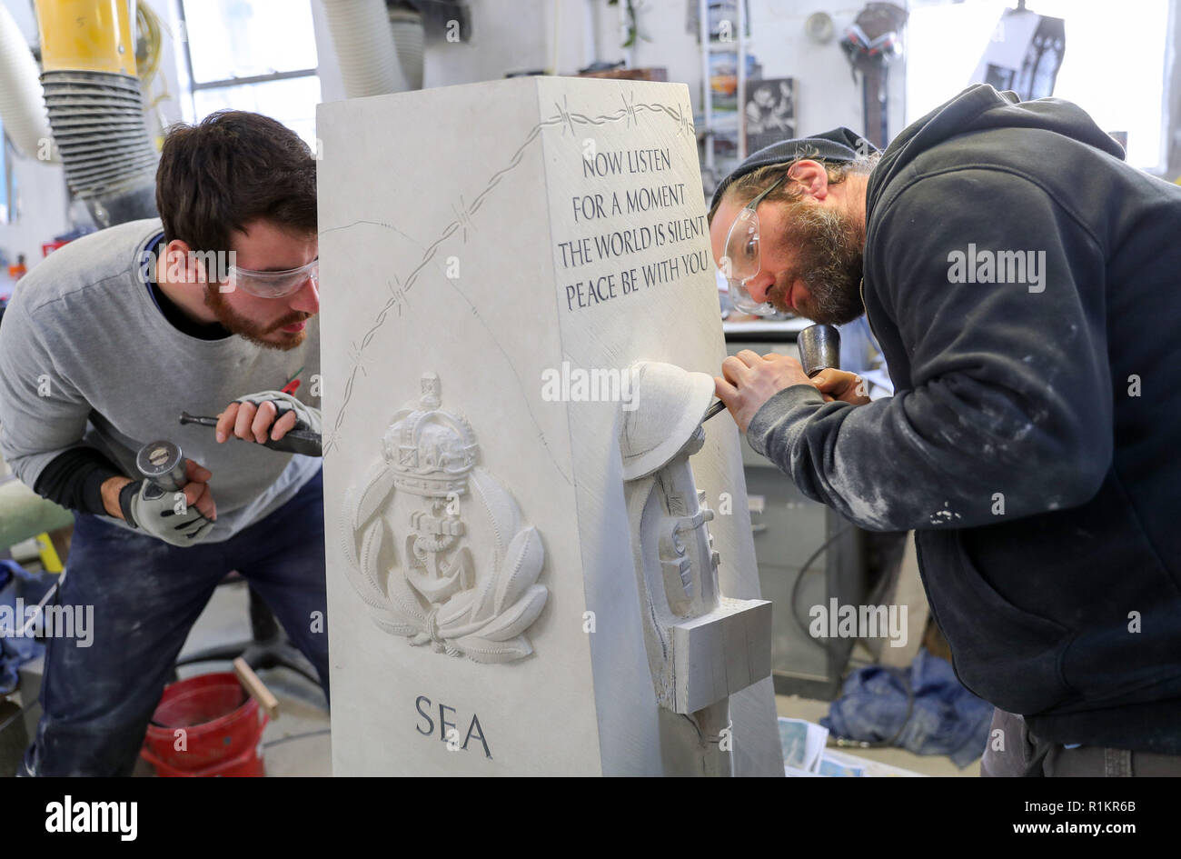 Stone masons from Salisbury cathedral work on a war memorial in their workshop which was designed by prisoners from Erlestoke prison in Wiltshire, and will be placed outside the prison's visitor's centre. Stock Photo