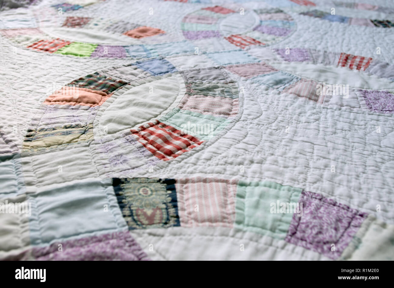 White and colorful patchwork hand sewn double wedding ring quilt from the American South close up Stock Photo