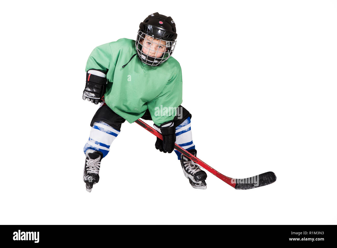 Boy playing ice hockey. Little hockey player isolated on white